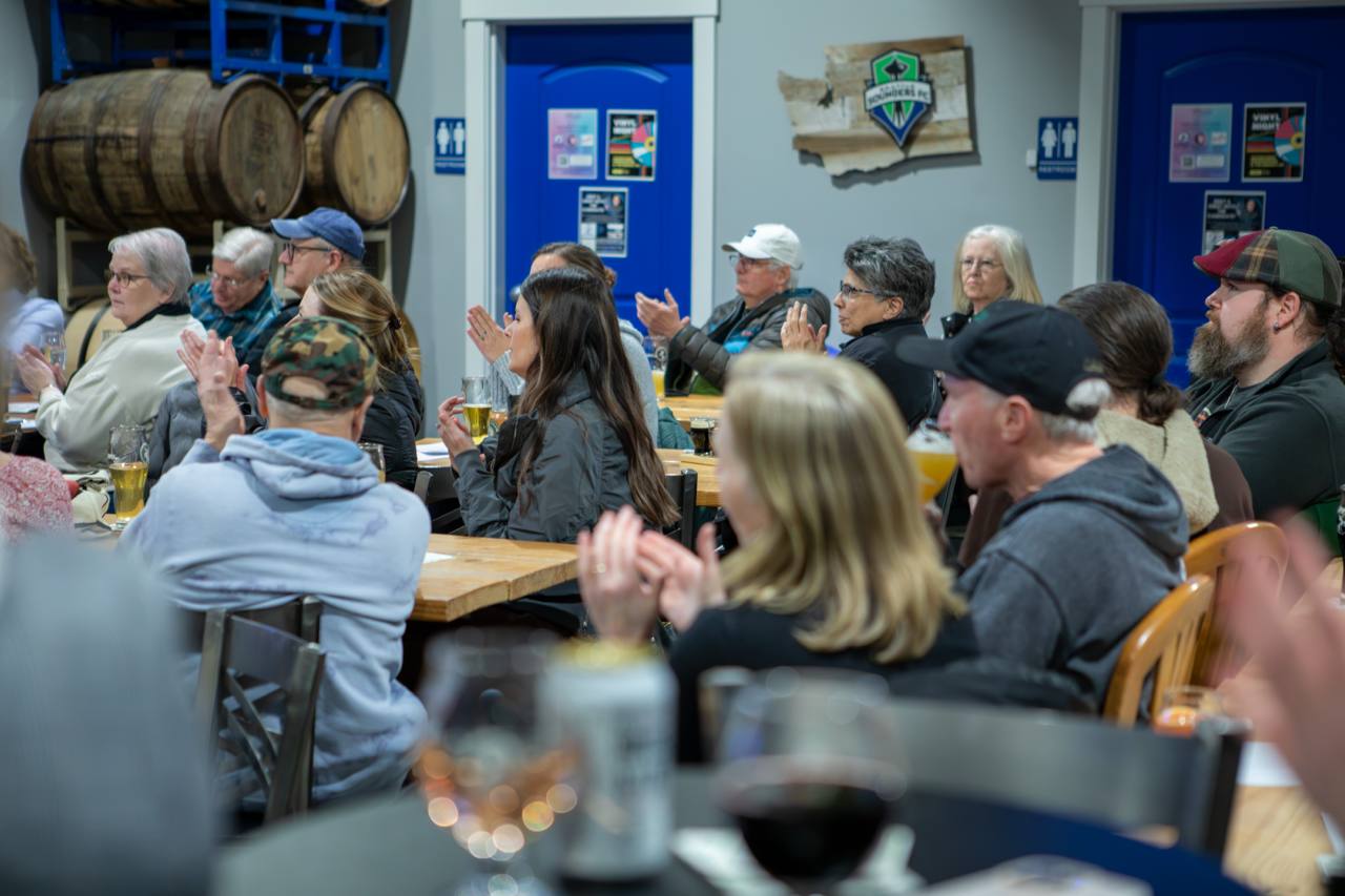 Community members applauding at a campaign event